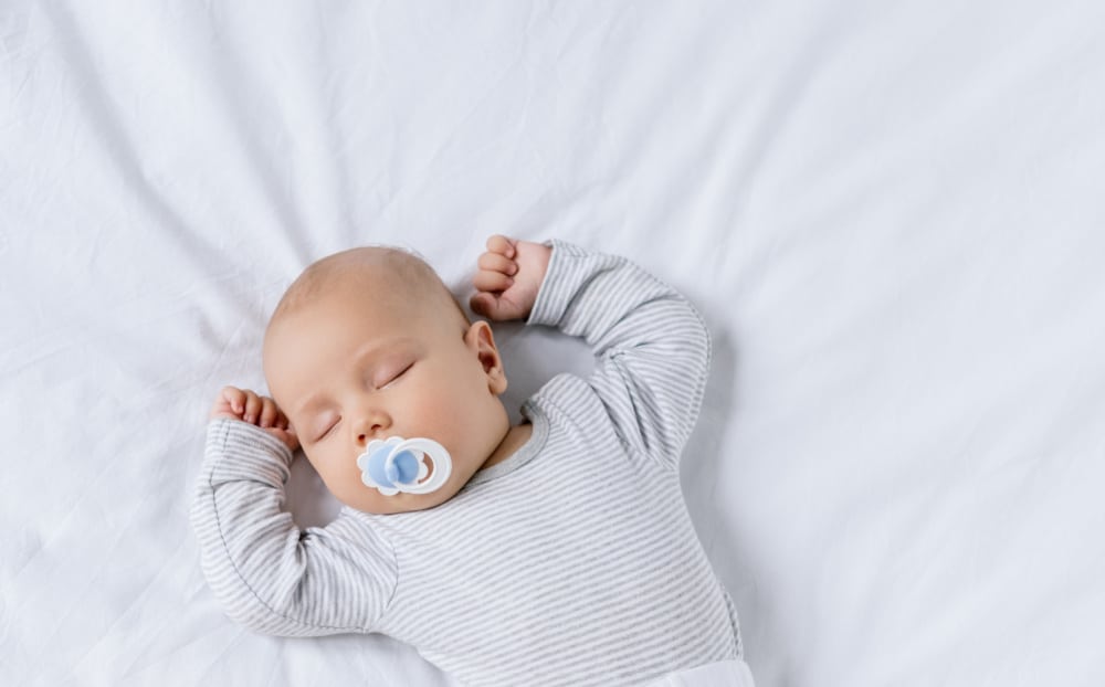 4 month old baby sleeping on back with pacifer