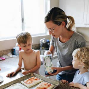 mom making pizza with her two small children