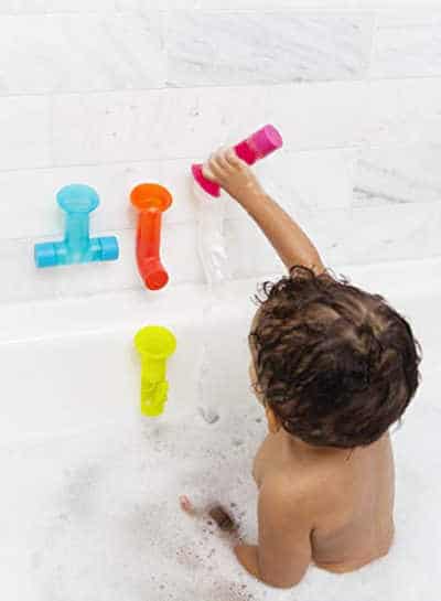 child playing with set of water pipes