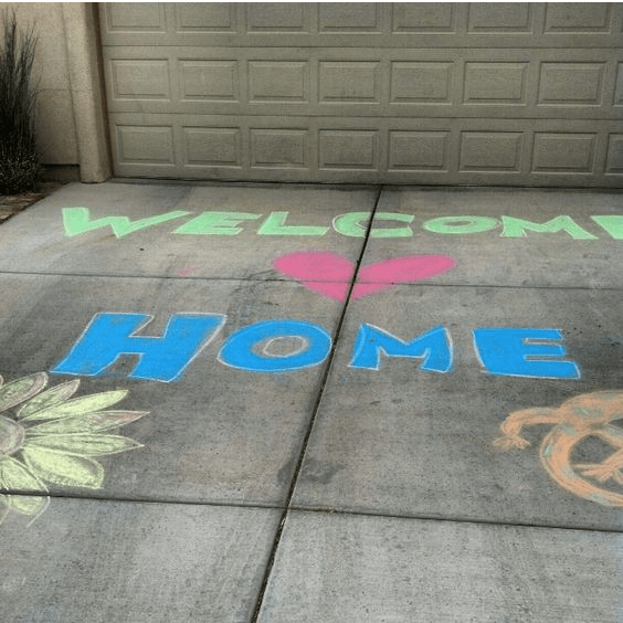 welcome home written on driveway with chalk