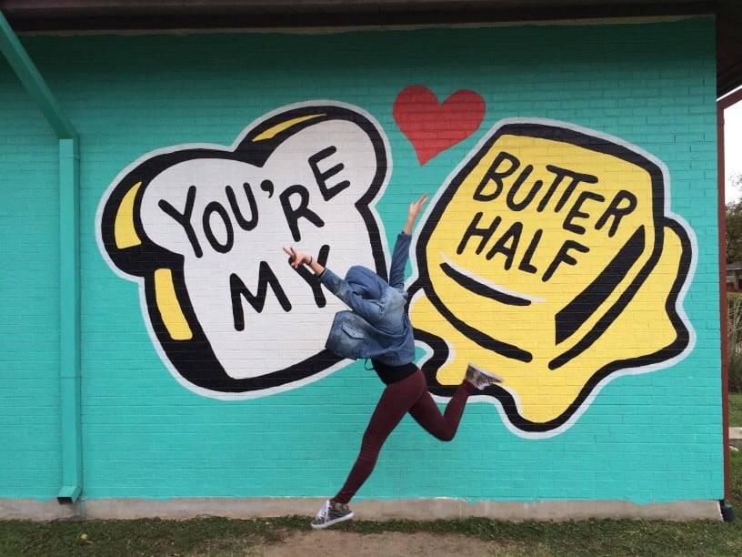 Graffiti art of bread and butter on wall that reads "You're my butter half." 