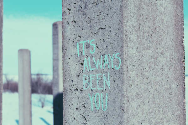 Graffiti art on concrete pillar that reads "It's always been you." 