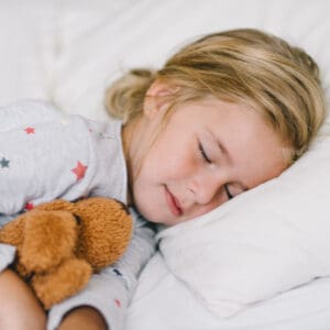 preschooler sleeping holding stuffed animal